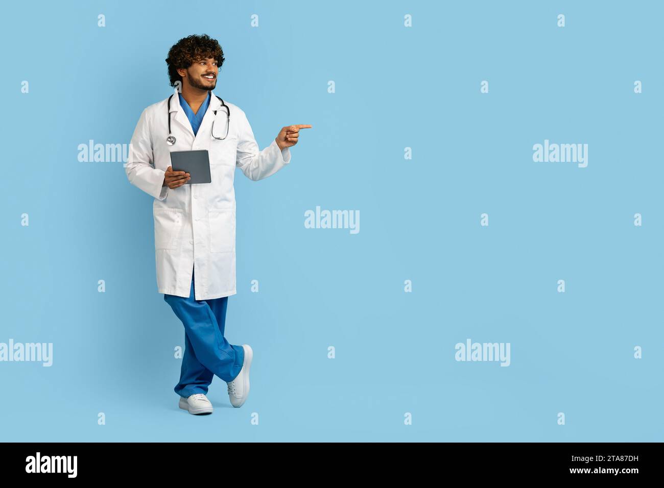 Handsome indian doctor using digital tablet to conduct remote appointments Stock Photo
