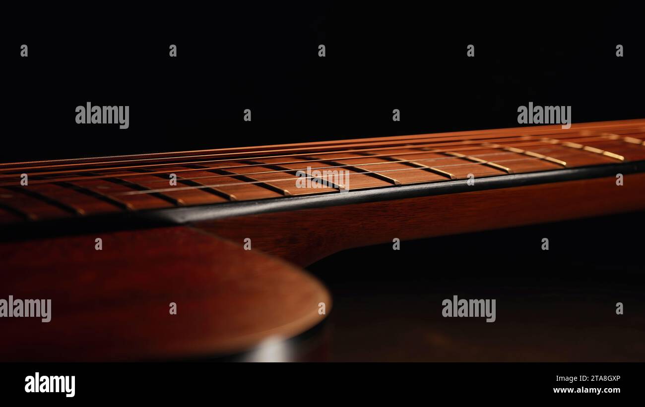 Macro of strings on redwood acoustic guitar fretboard. Classical music