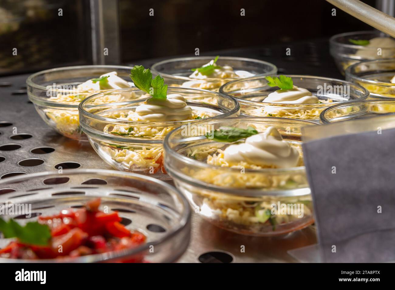 Plates with various pastries in the cafeteria window. Cooling showcase for salads in the dining room or cafeteria Stock Photo