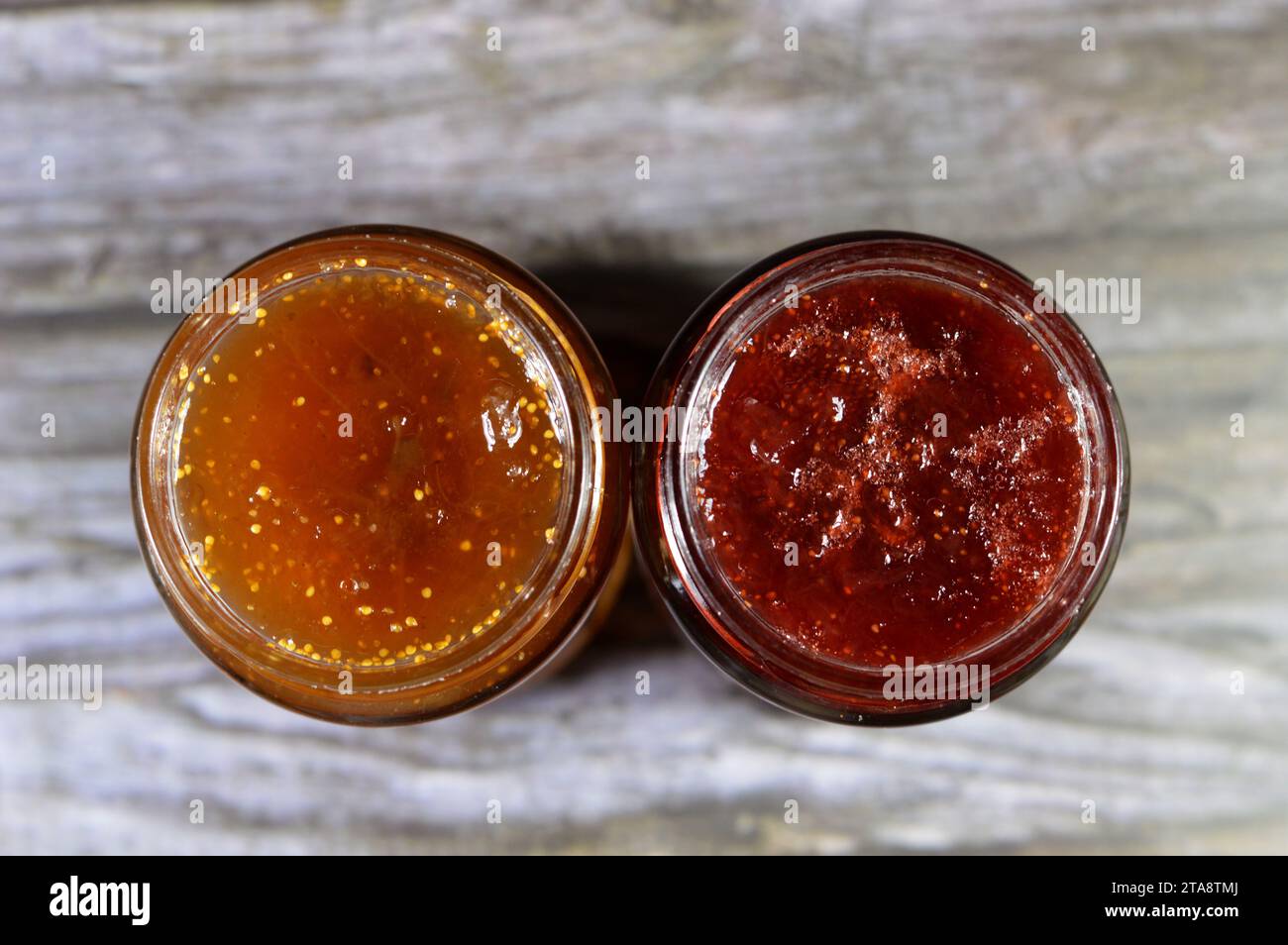 Fig fruit and strawberry jam bottles, preparations of fruits whose main preserving agent is sugar and sometimes acid, often stored in glass jars and u Stock Photo