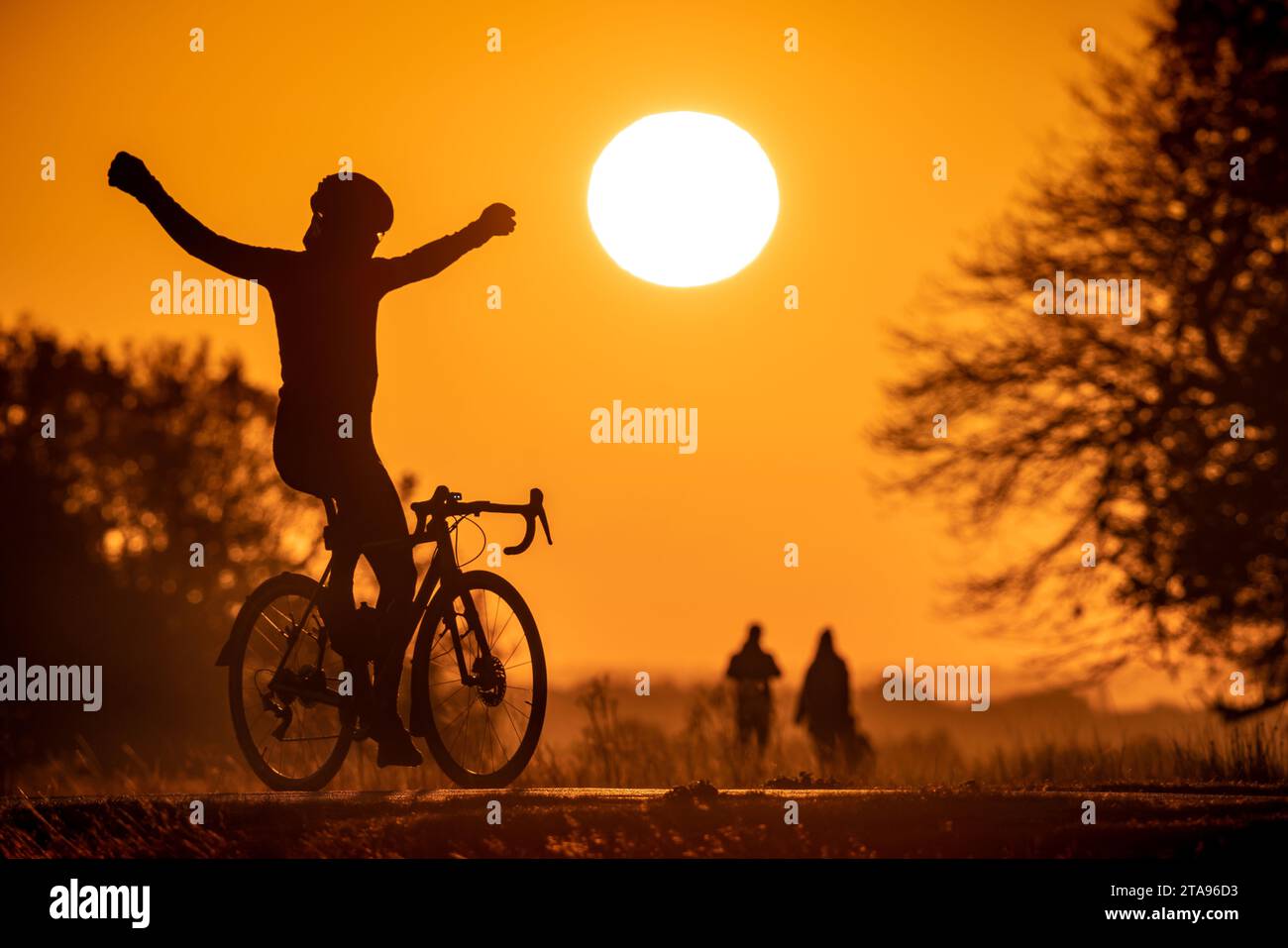 UK Weather: A cyclist celebrates the glorious morning sunrise over Richmond Park in London. Stock Photo