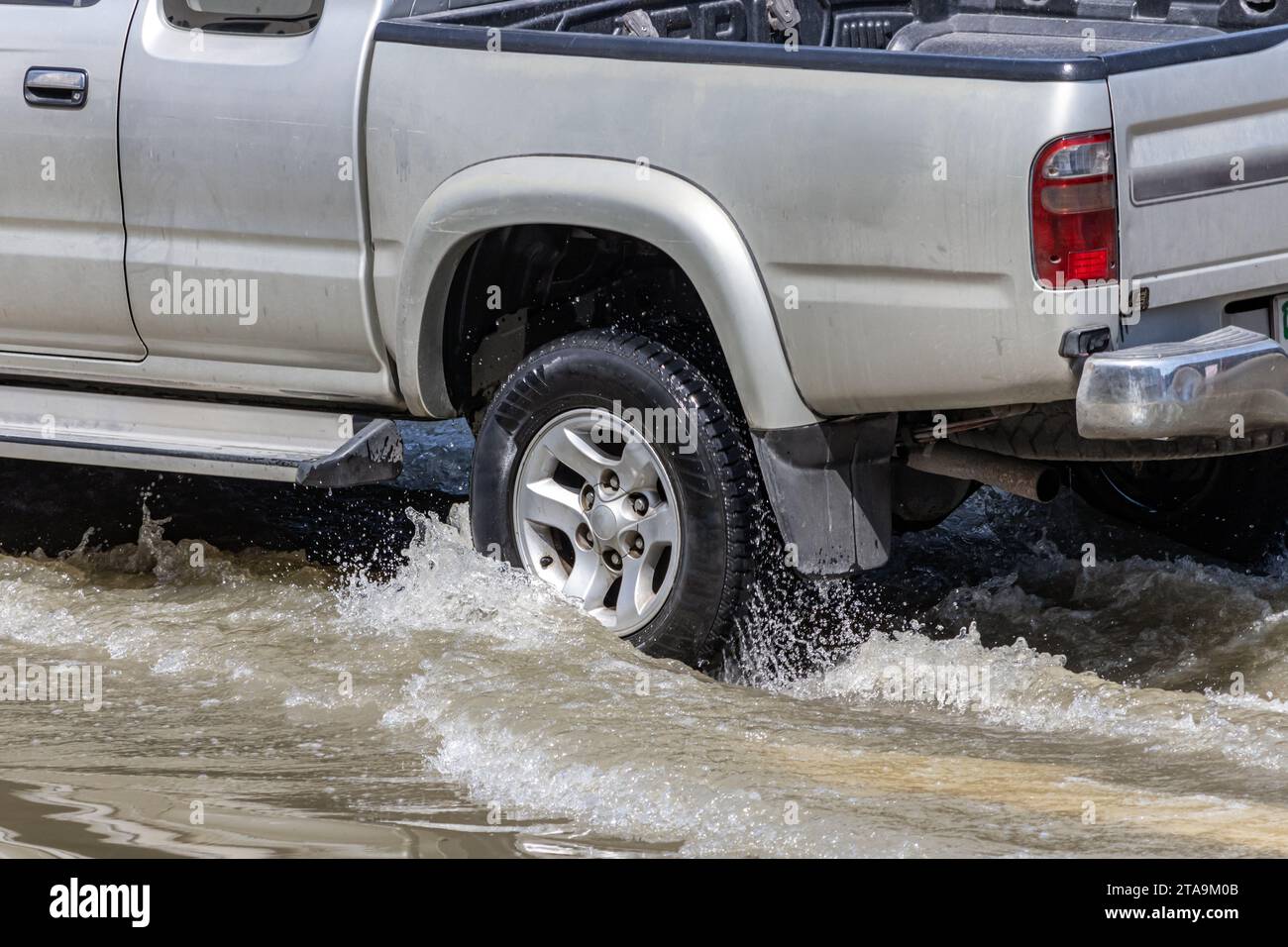 A pickup truck drives through a flooded street in the city, Bangkok, Thailand Stock Photo