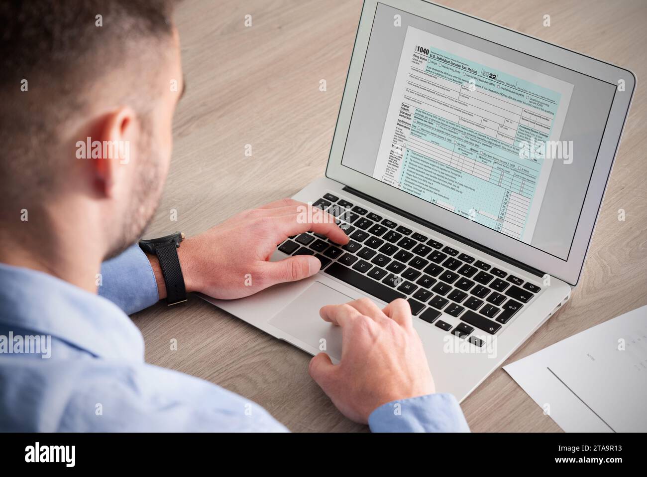 Man filling tax form with laptop. Tax refund Stock Photo