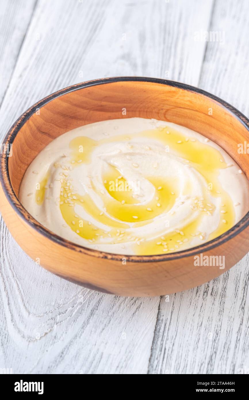 Wooden bowl of hummus on the white background Stock Photo