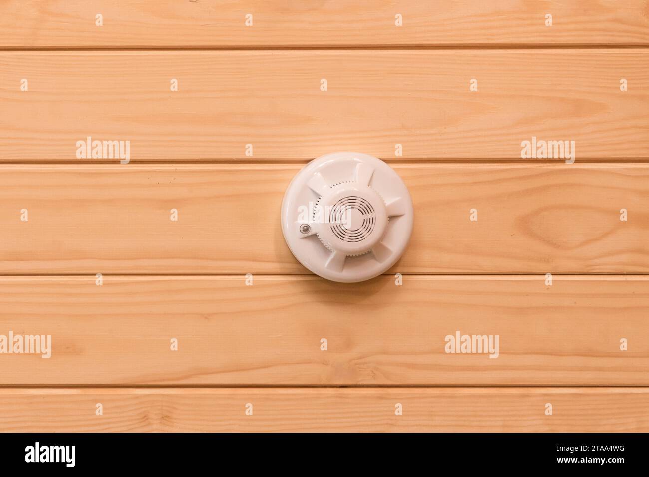 Fire alarm on wooden ceiling smoke detector safety and home protection from dangerous with fire, close-up. Stock Photo