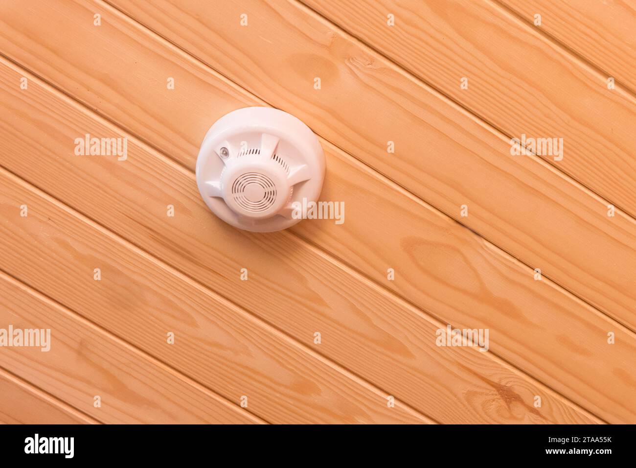 Fire alarm wooden color ceiling smoke detector safety and home protection from dangerous with fire, close-up. Stock Photo