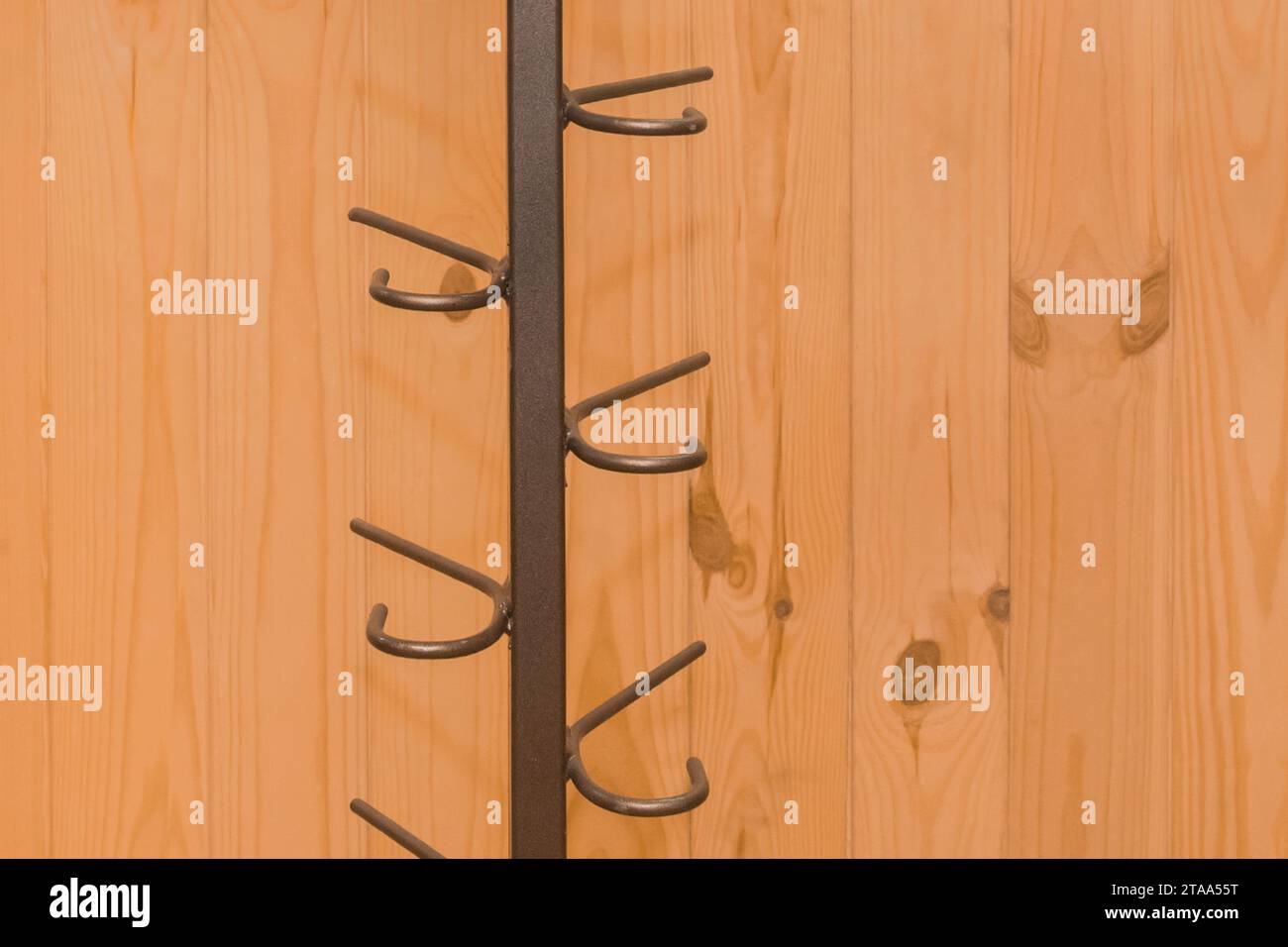 Metal structure clothes hanger hooks on wooden background close-up. Stock Photo