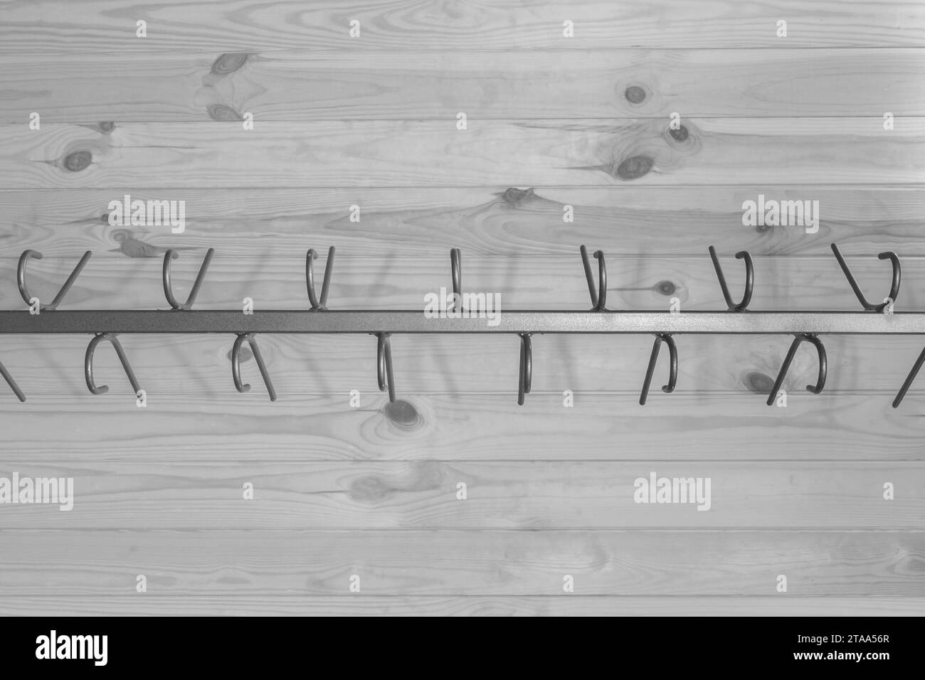 Metal structure clothes hanger hooks on wooden gray background close-up wardrobe. Stock Photo