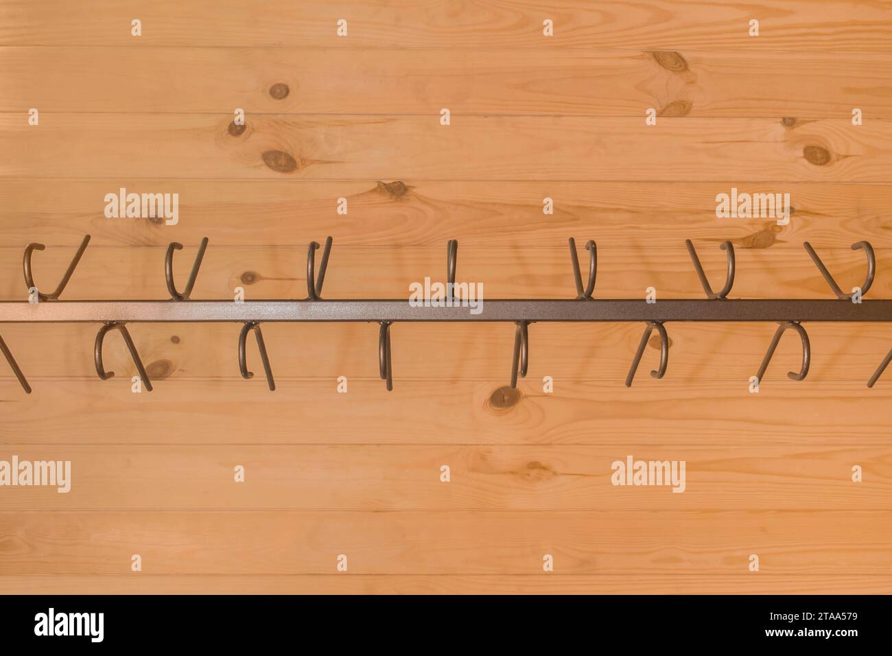 Metal structure clothes hanger hooks on wooden background close-up wardrobe. Stock Photo