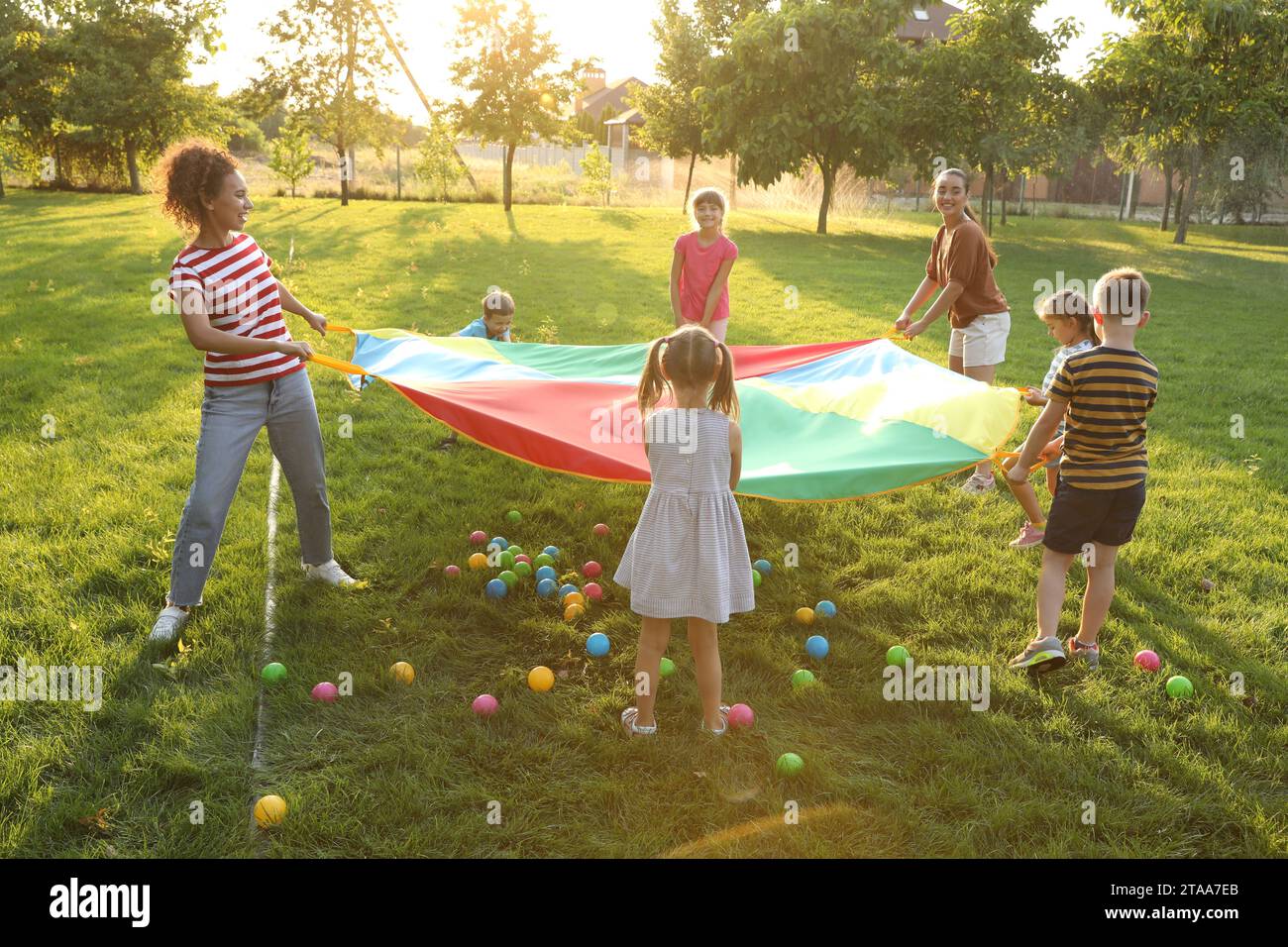 Group of children and teachers playing with rainbow playground