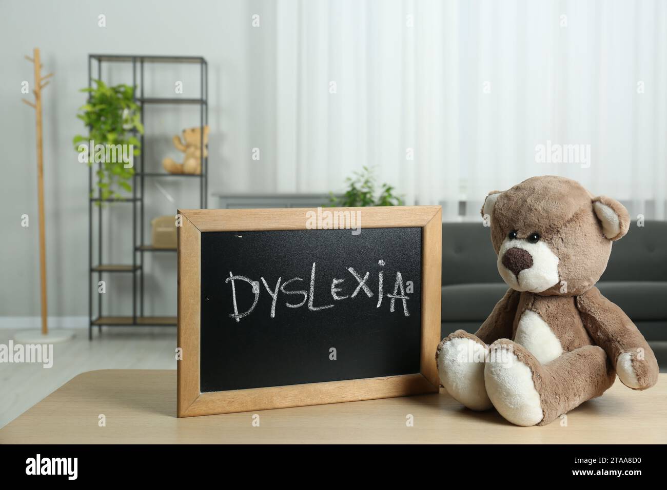 Teddy bear and small blackboard with word Dyslexia on wooden table ...