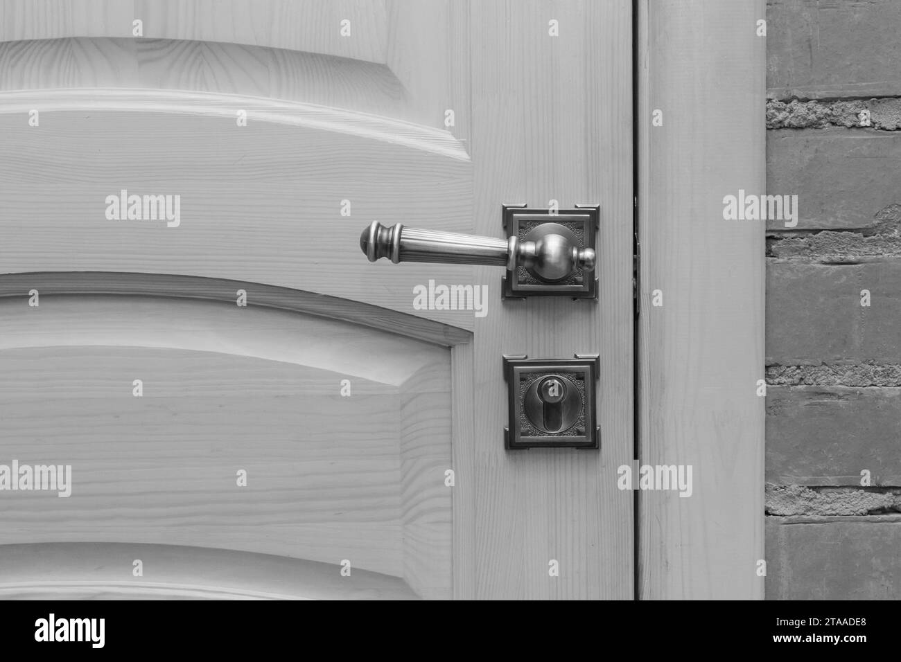 Close-up grey wooden gray door metal handle object detail interior indoor. Stock Photo
