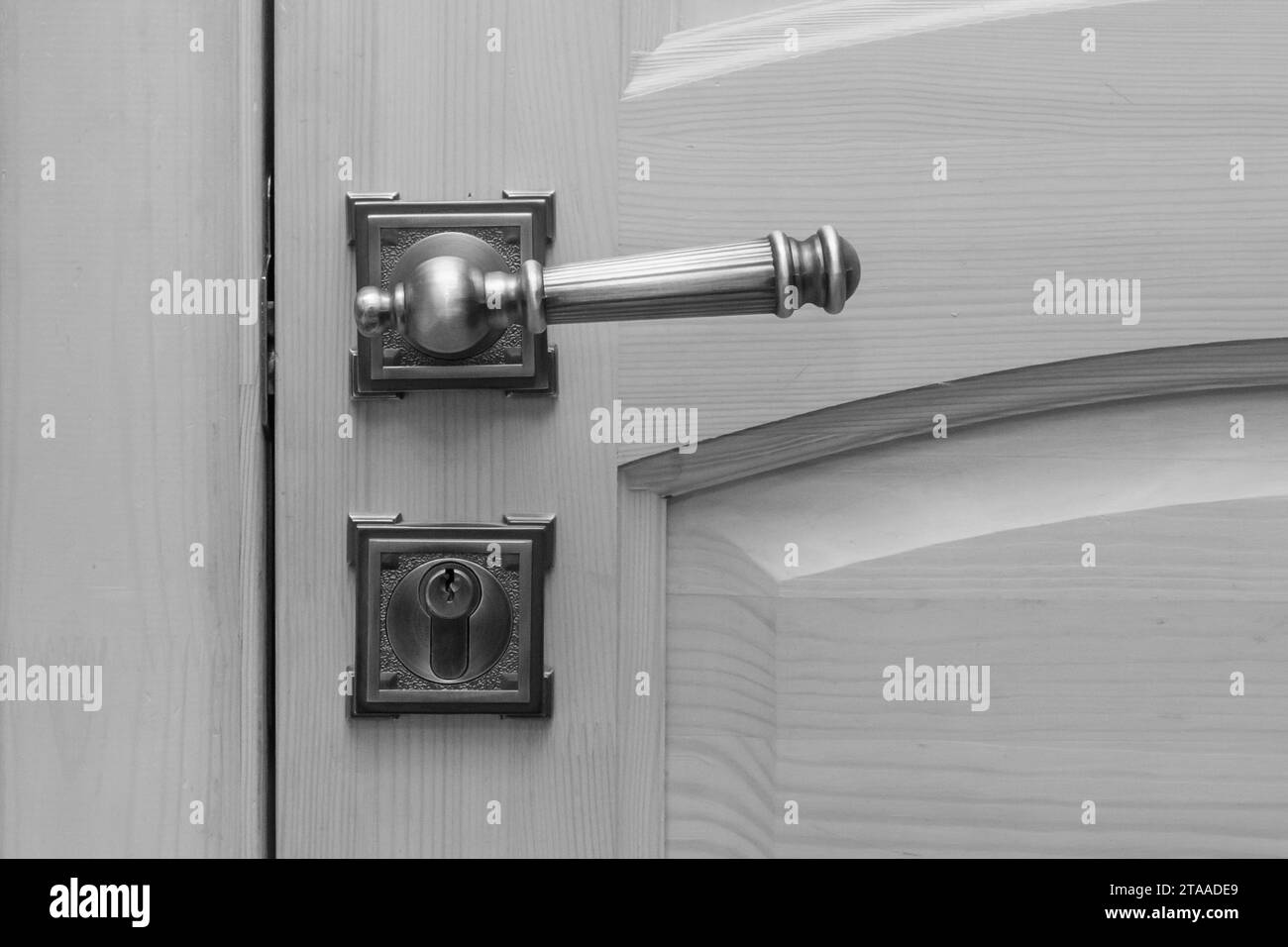 Close-up macro grey wooden door metal handle object detail indoor. Stock Photo