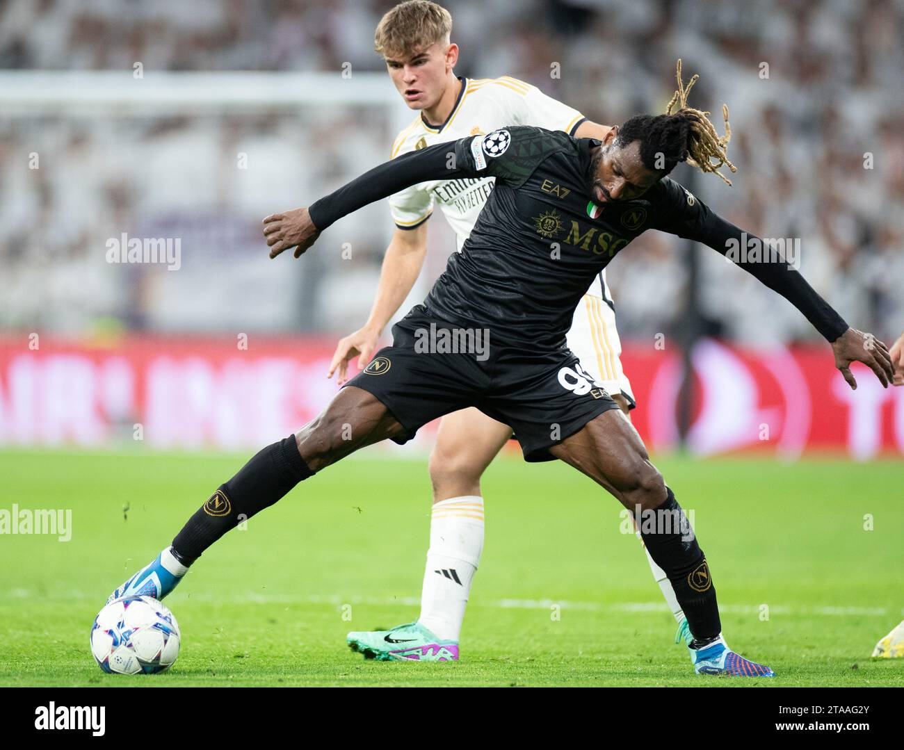 Madrid, Spain. 29th Nov, 2023. Real Madrid's Nicolas Paz (back) vies with Napoli's Andre-Frank Zambo Anguissa during the UEFA Champions League Group C match between Real Madrid and SSC Napoli at the Santiago Bernabeu Stadium in Madrid, Spain, on Nov. 29, 2023. Credit: Meng Dingbo/Xinhua/Alamy Live News Stock Photo