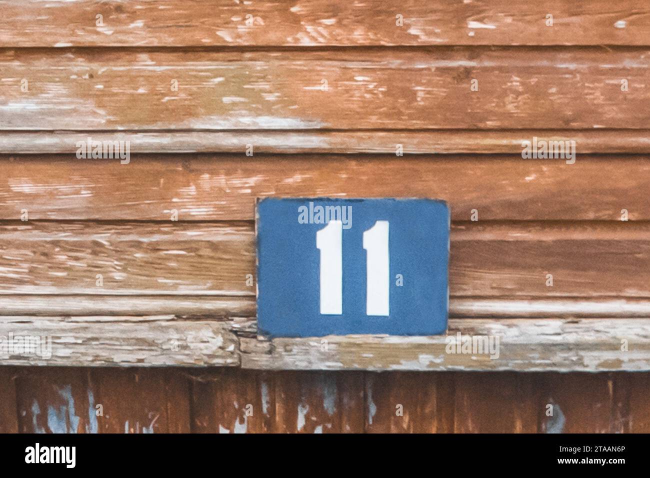 Symbol sign number 11 eleven house object close-up home macro soft focus on wooden background. Stock Photo
