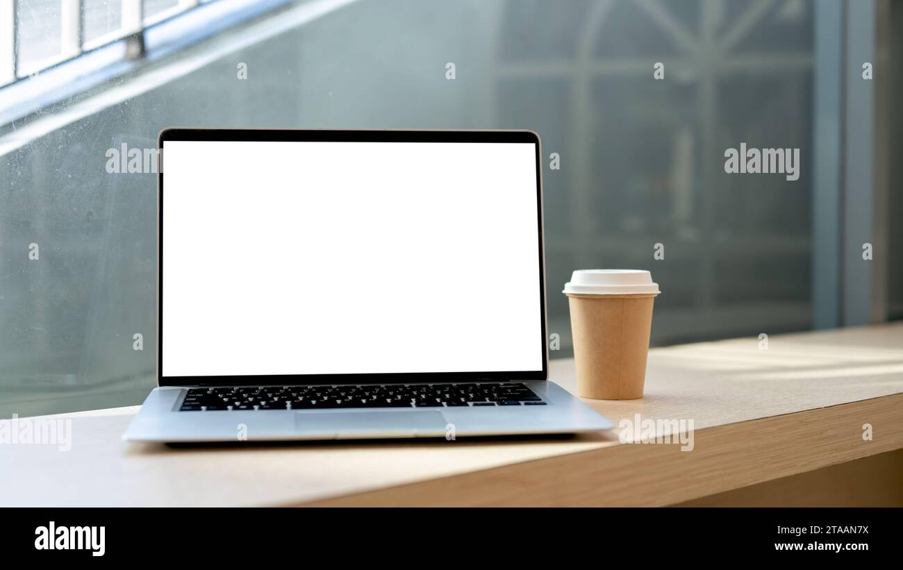 Close-up image of a white-screen laptop computer mockup and a coffee ...