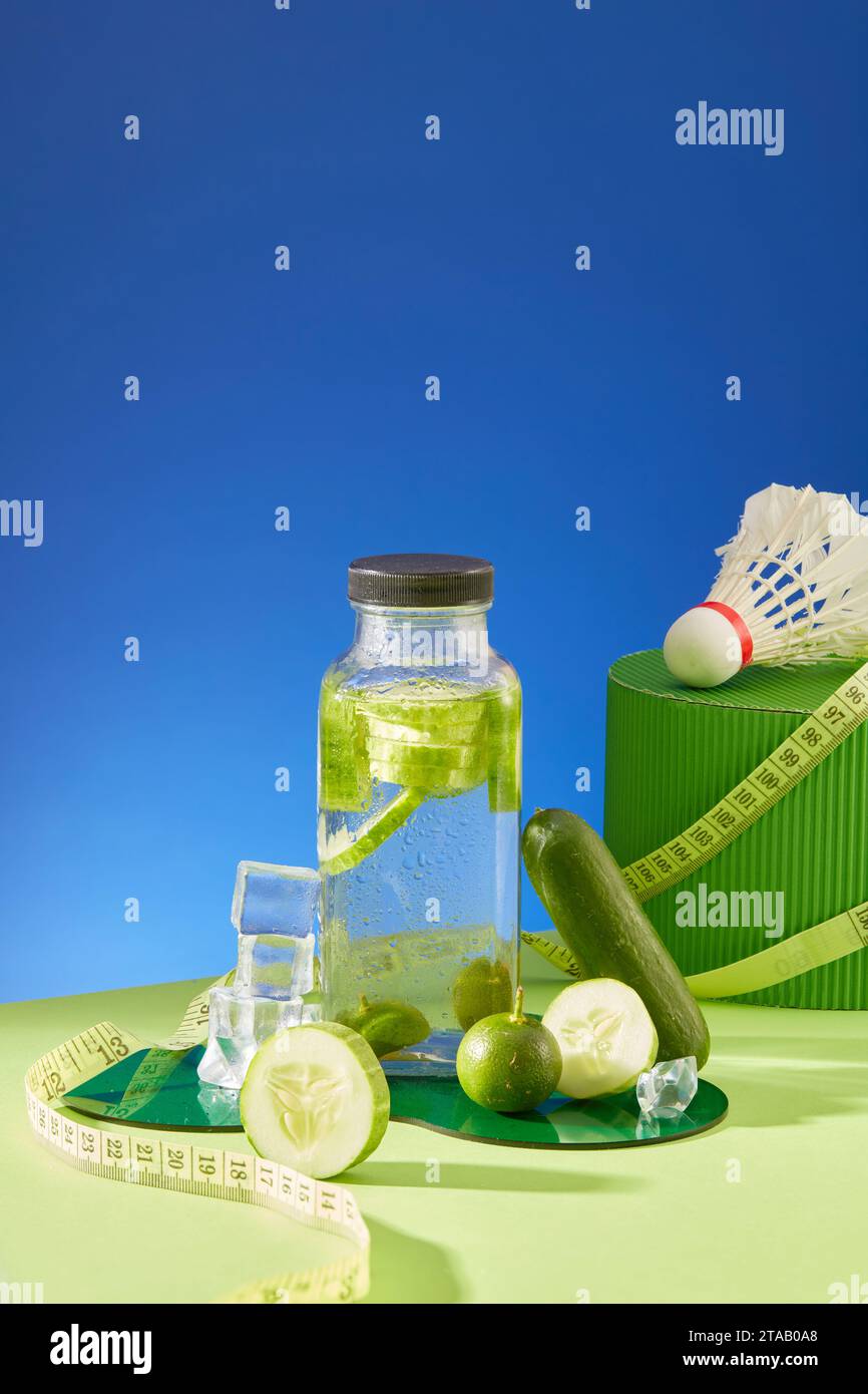 Front view of detox water bottle decorated with kumquats and cucumber cut in round slices. Cucumber has the ability to reduce swelling and puffiness o Stock Photo