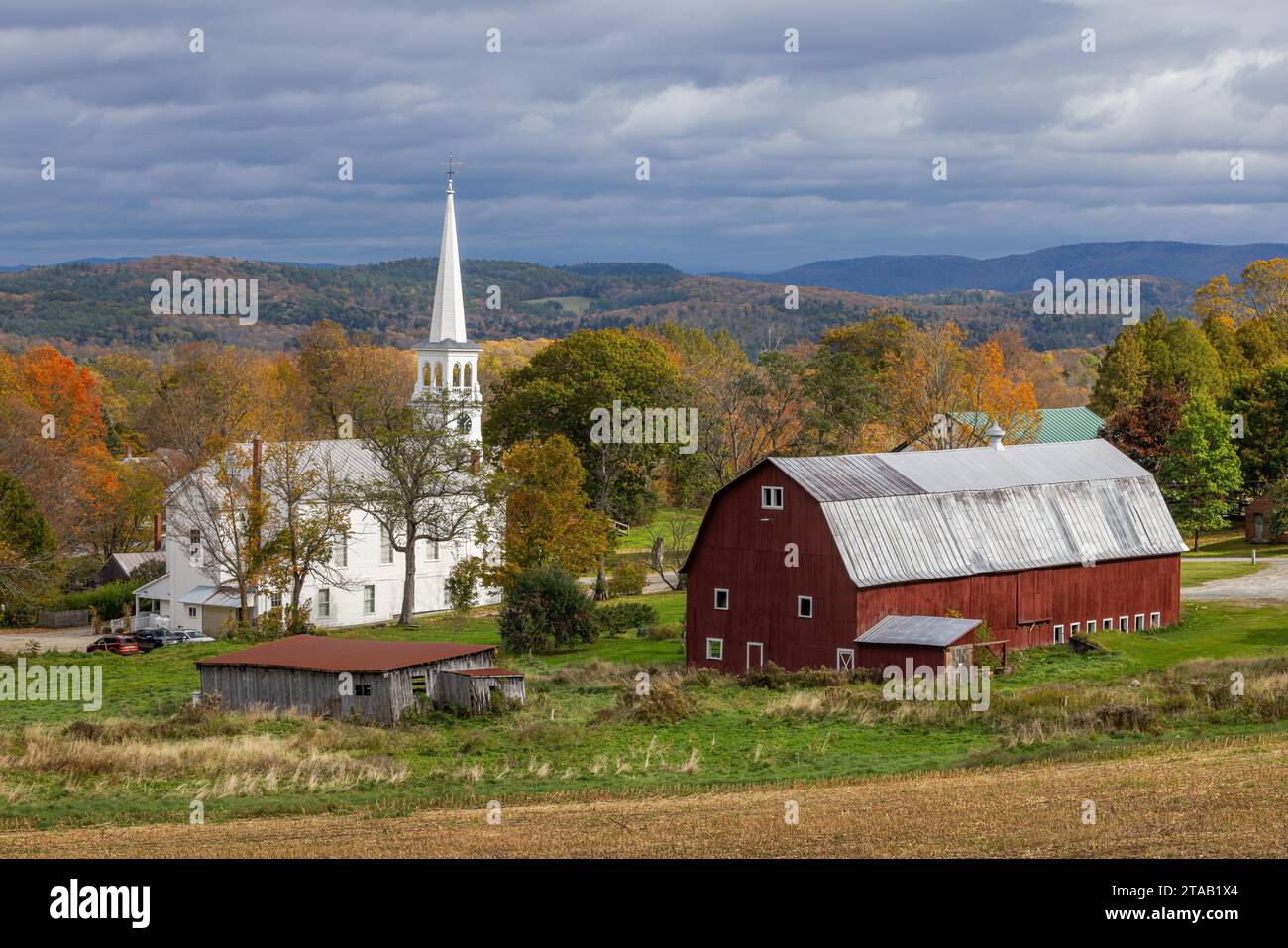 Peacham Congregational Church and red barn in autumn, Peacham, Vermont Stock Photo