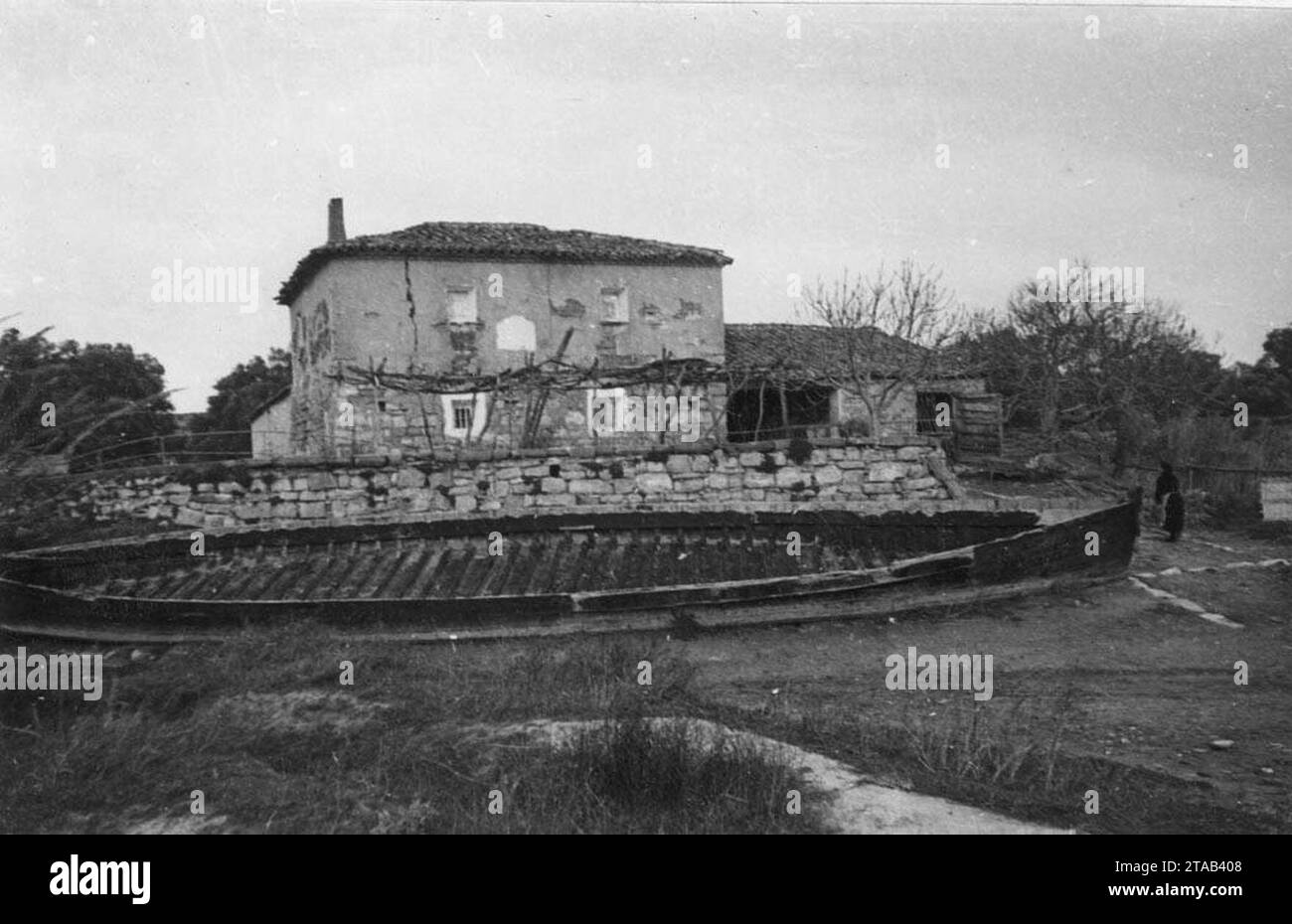 Vista general de la Casa del Barquer de l'Ebre, en primer terme una barca abandonada. Stock Photo