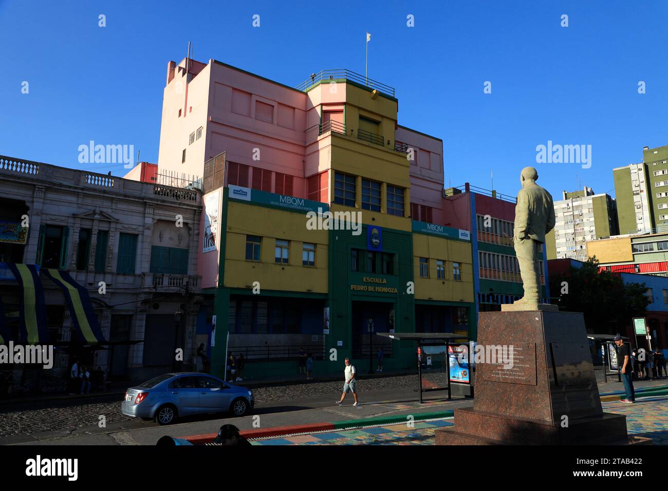 The statue of Benito Quinquela Martín in the riverwalk of Riachuelo River with the colorful buildings in La Boca district.Buenos Aires.Argentina Stock Photo