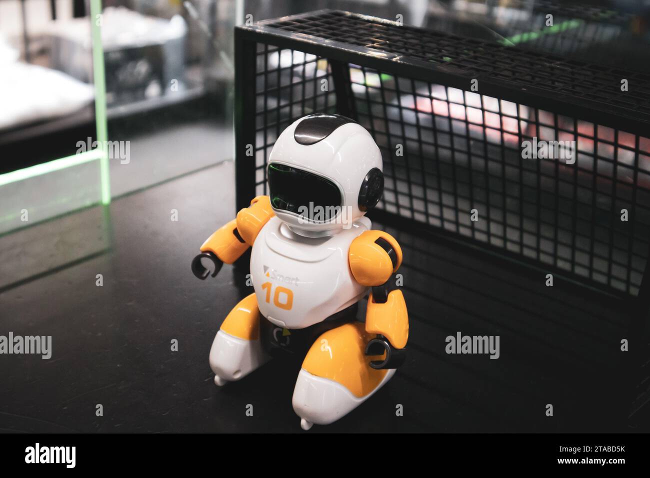 Mini toy yellow robot goalkeeper on soccer goal. Robotic Character