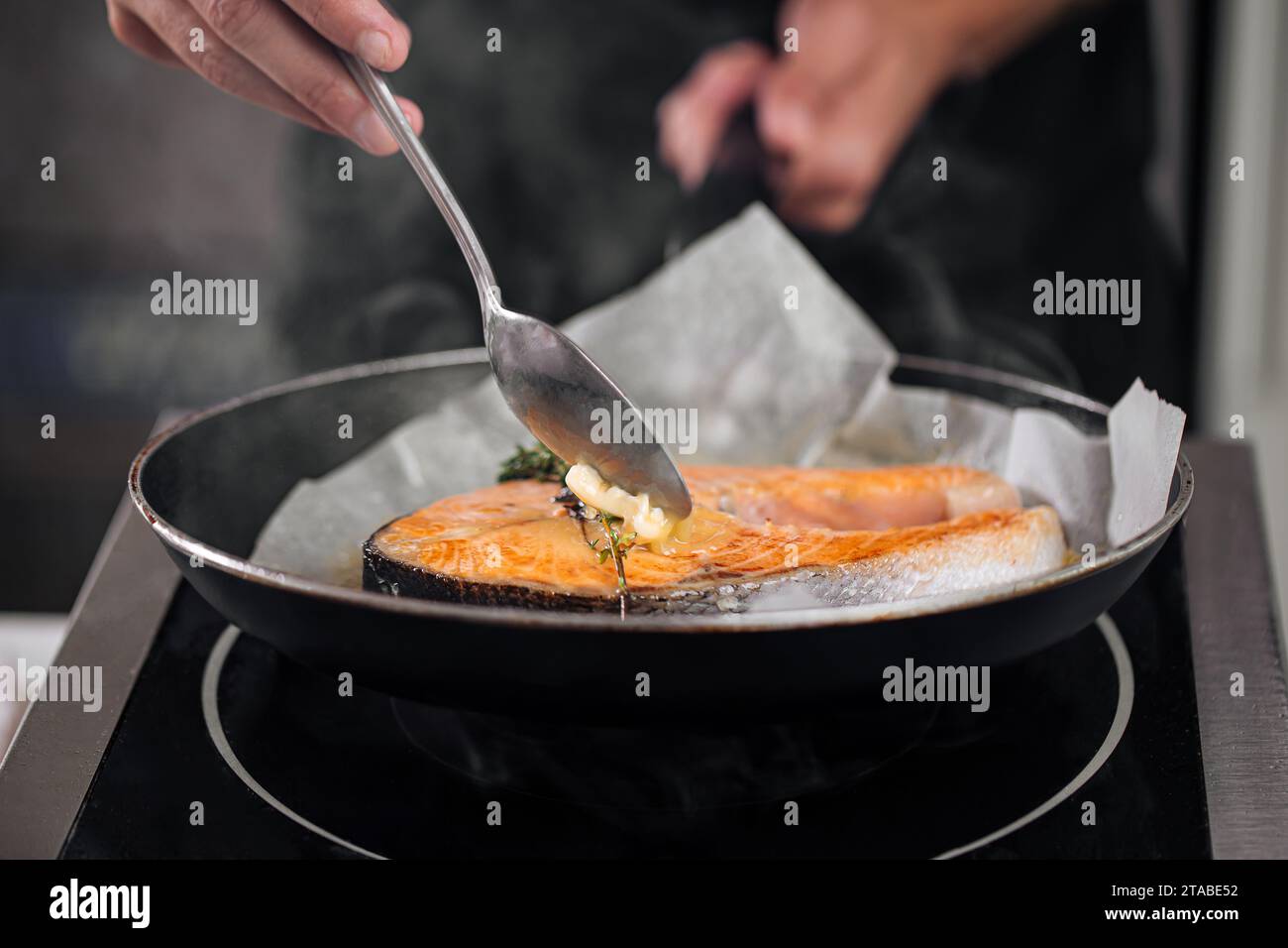 Man cooking salmon steak roasting on parchment Stock Photo