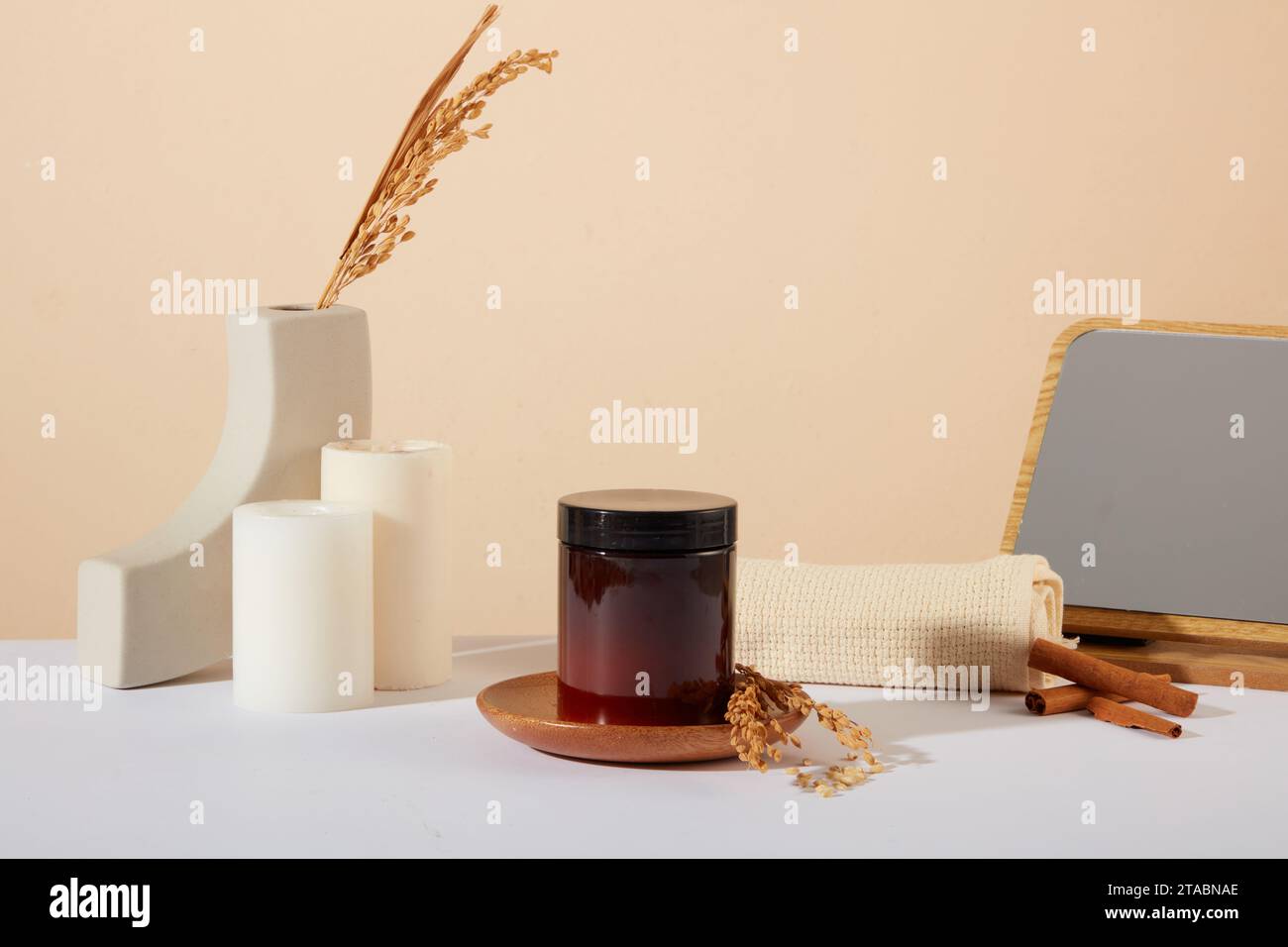 Unlabeled scrub jar on a wooden dish, showcasing a cosmetic derived from rice bran. Rice bran, known for exfoliation, helps remove dead skin cells, pr Stock Photo