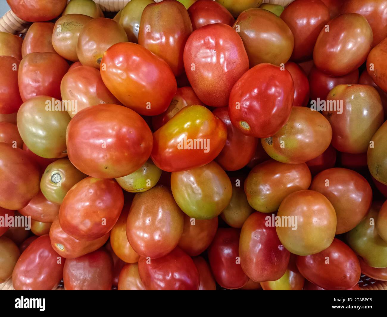 Tomatoes lying on a pile on top of each other, tomato texture. Selective focus Stock Photo