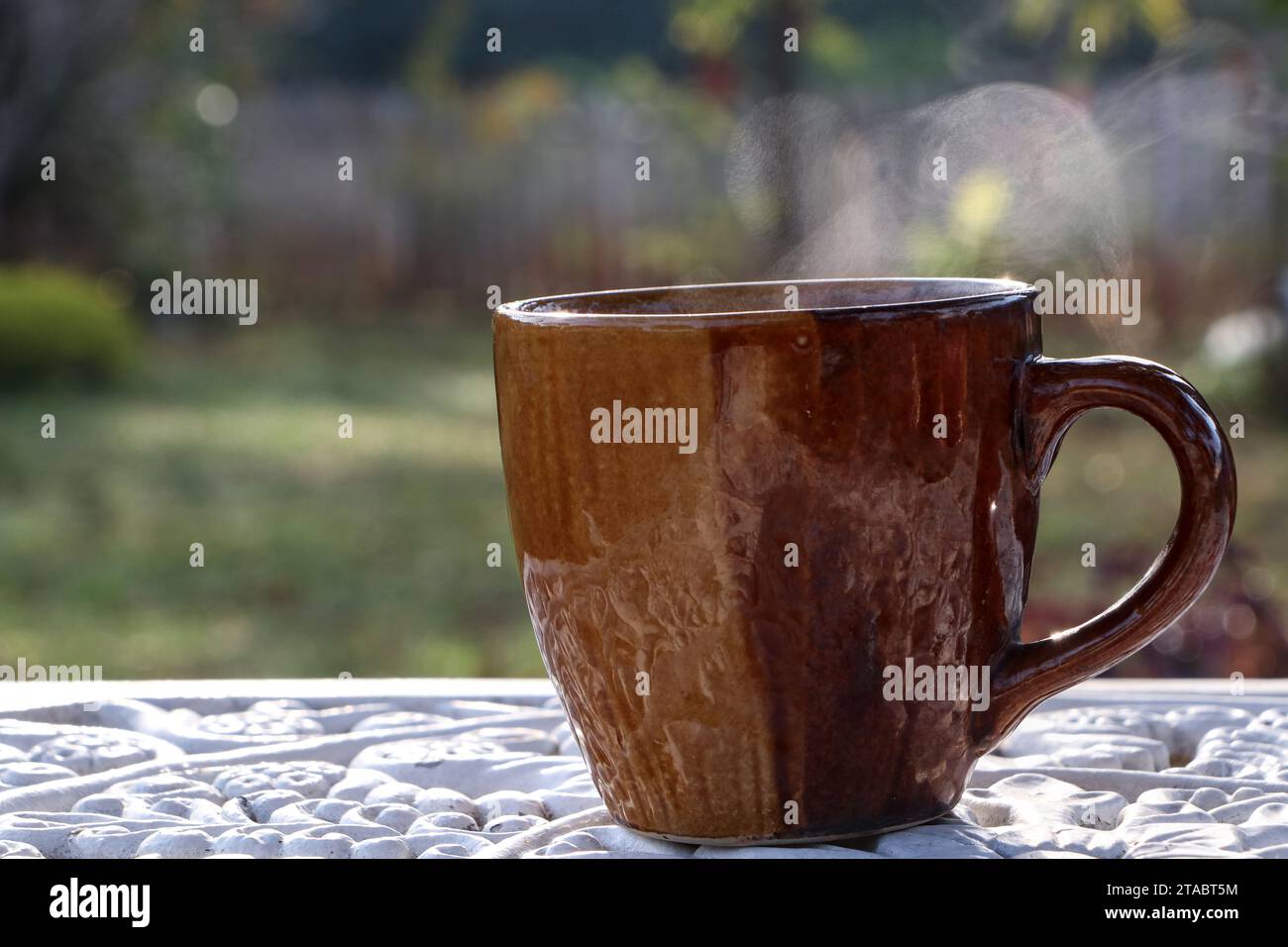 Cup of coffee on white table with hot smoke and blurred focus background Stock Photo
