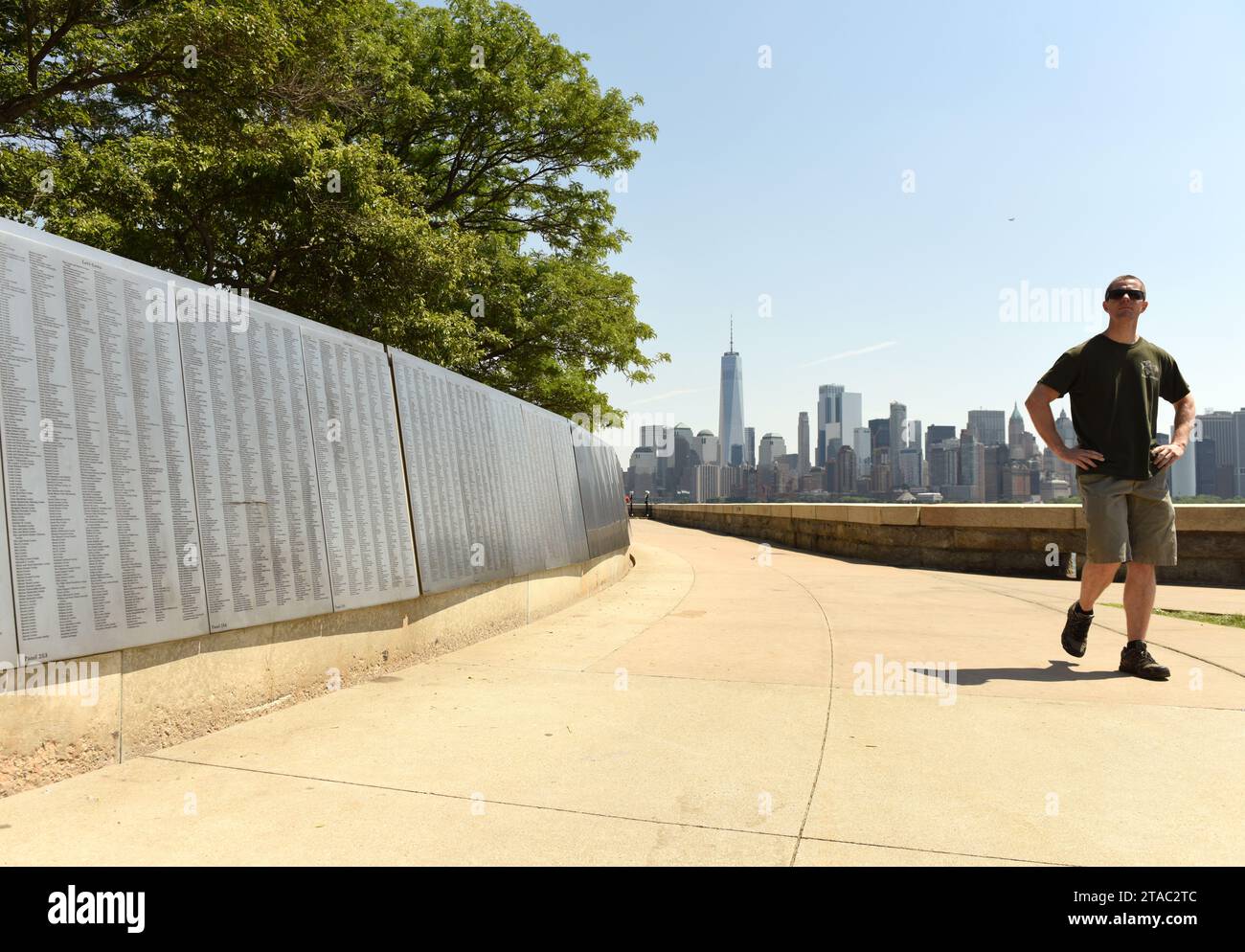New York, USA - June 09, 2018: Man near the American Immigrant Wall of Honor is located at the Ellis Island National Museum overlooks the Lower Manhat Stock Photo