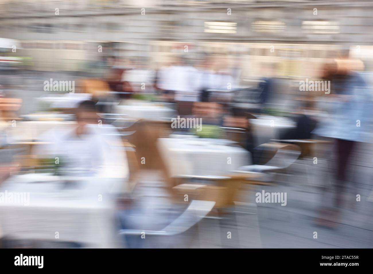 Motion effect in photography. Slow time exposure. Outdoor restaurant. People Stock Photo