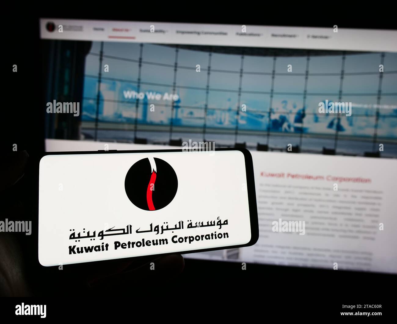 Person holding mobile phone with logo of Kuwaiti oil company Kuwait