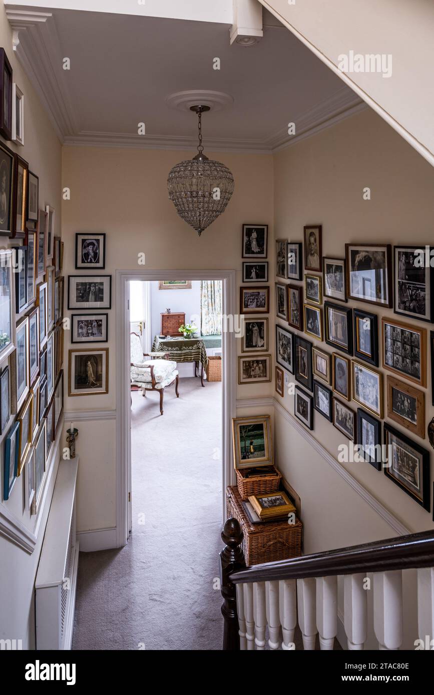 Picture wall and banister in hallway of late 19th century West London home. Stock Photo