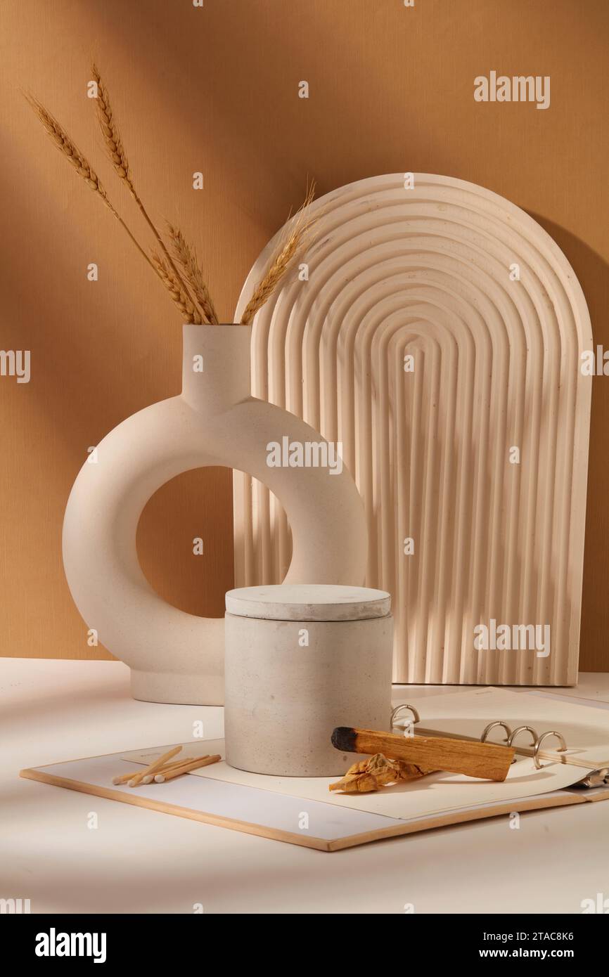 A jar of scented candles is displayed on a table with props. White