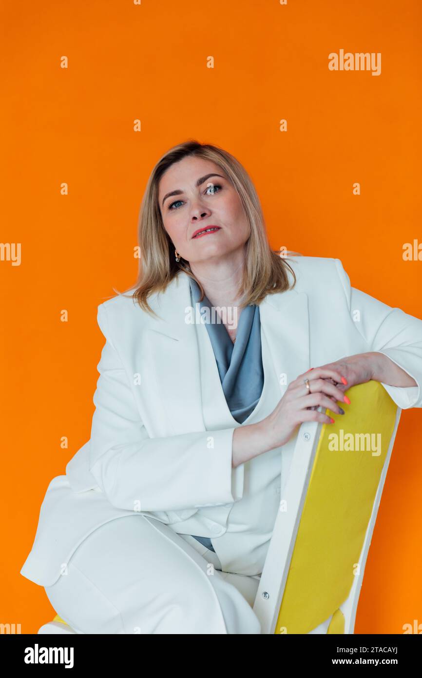 Beautiful adult woman in white business suit in orange office Stock ...