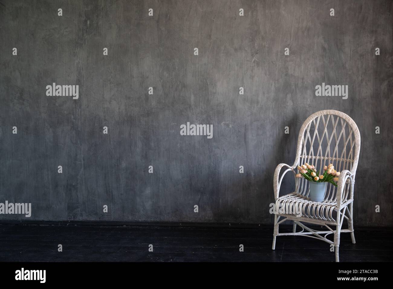 Vintage armchair with flowers in grey room interior Stock Photo - Alamy