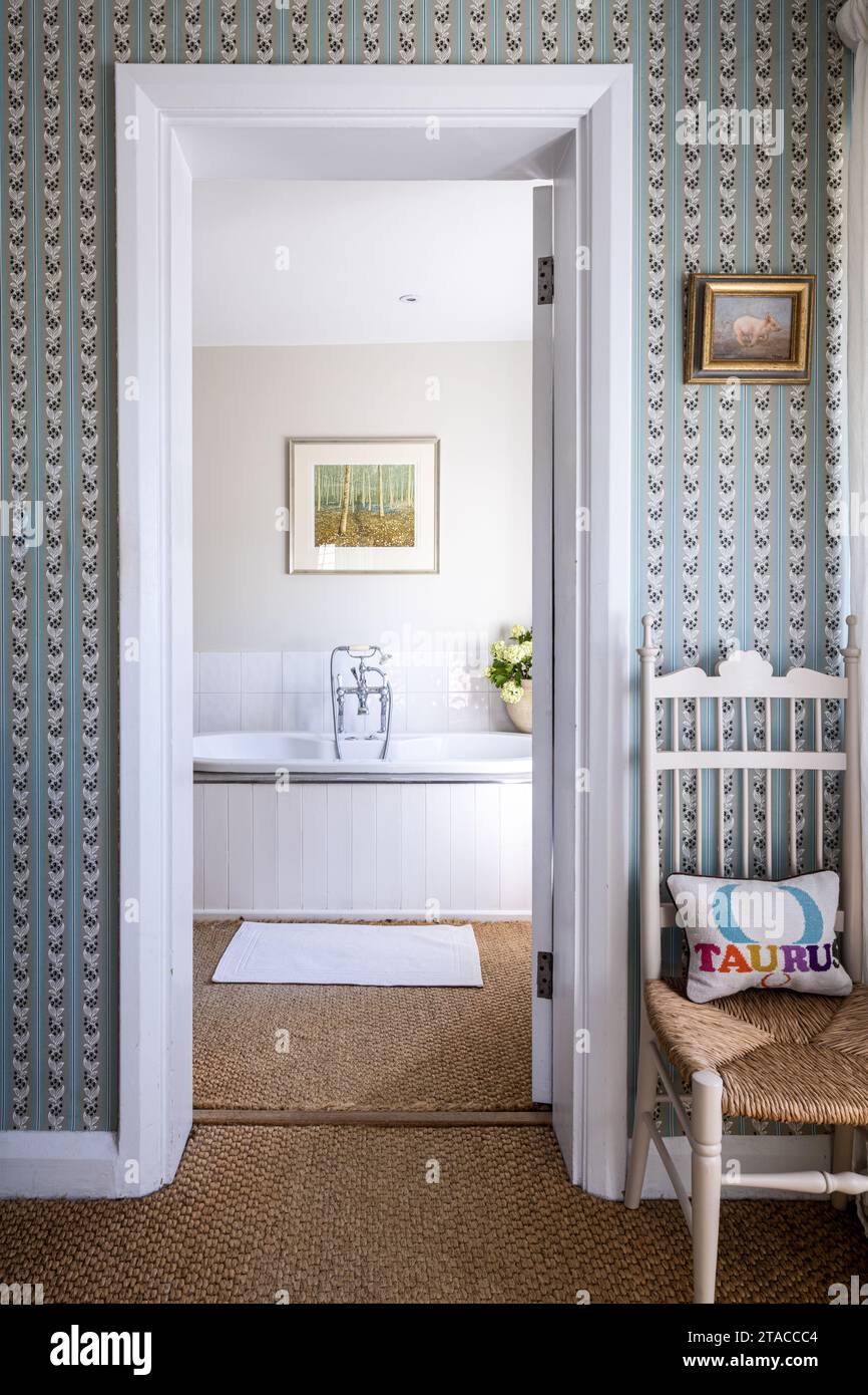 Wallpaper and coir matting with view to en suite in 1930s Arts and Crafts style home. Hove, East Sussex, UK. Stock Photo