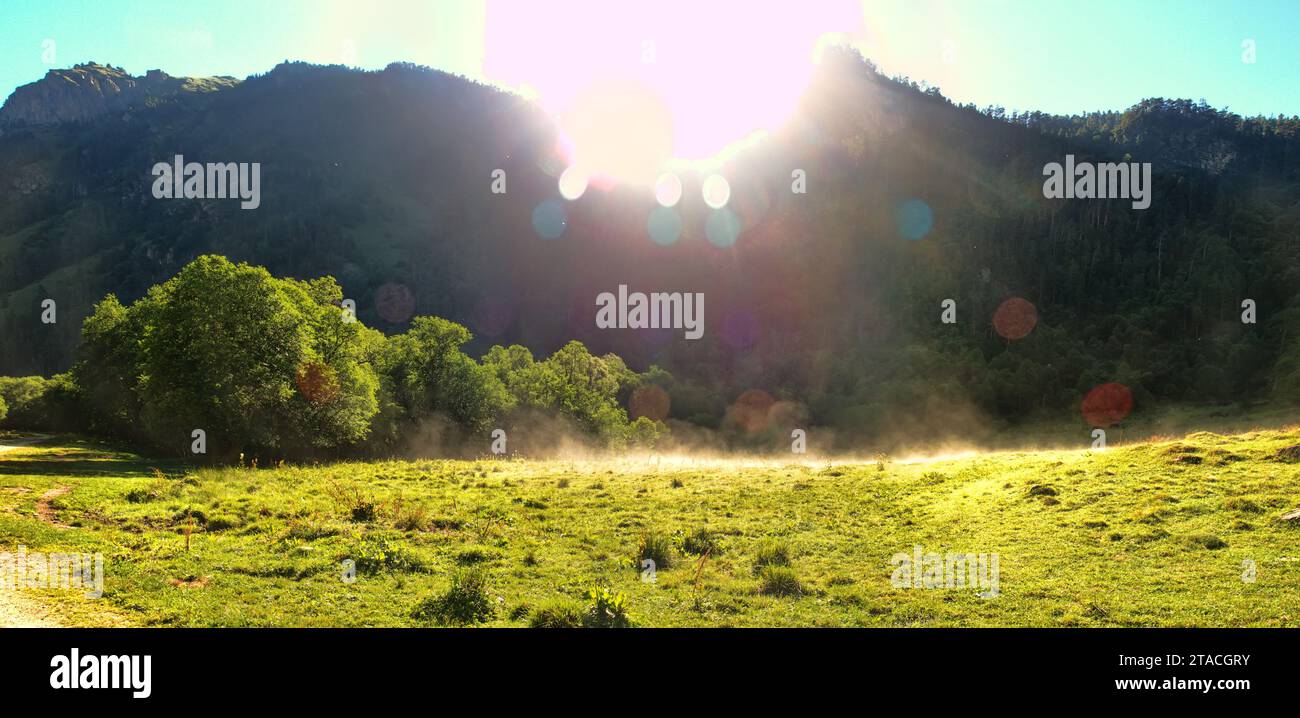 Morning in the mountains. Foothills, greenwood, rising sun, the steam ...