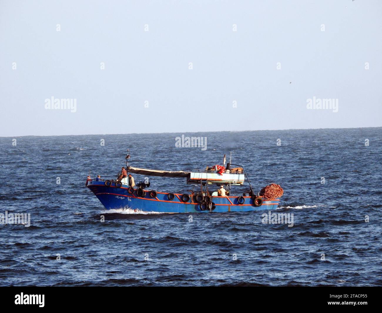 Alexandria, Egypt, September 10 2022: A fishing vessel with fishermen in Alexandria Mediterranean Sea, a boat or ship used to catch fish and other val Stock Photo