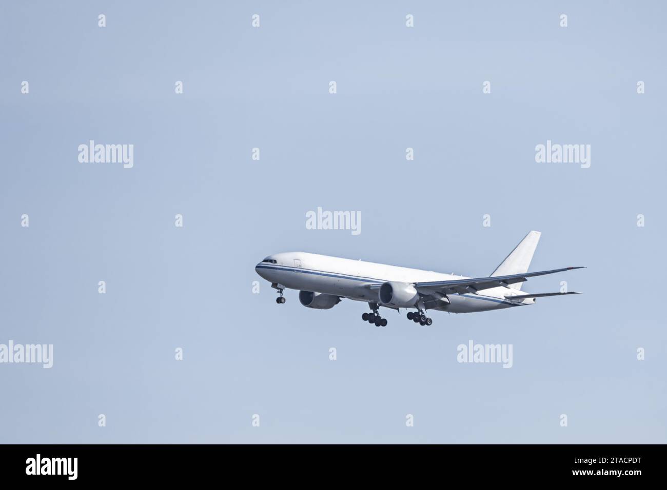 An airplane cargo jet descending altitude to land at an airport Stock Photo