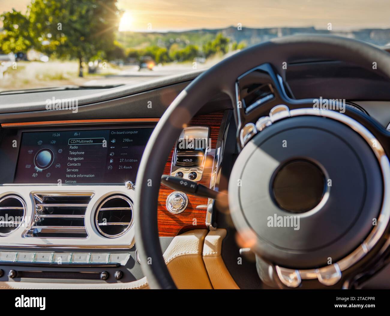 car breakdown , parked on the side of the road at sunset, car interior with multimedia radio, gauges and steering wheel . Stock Photo