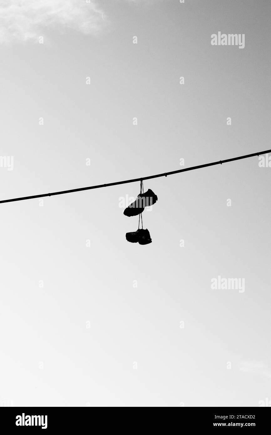 Shoes hanging from wire Stock Photo