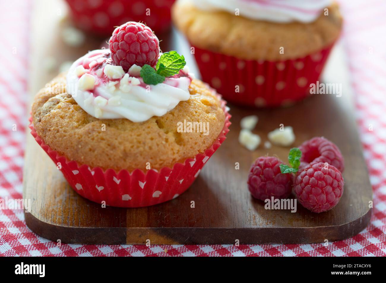 Homemade delight for refined palates: dive into the sweet temptation of raspberry cupcakes with white chocolate icing. An explosion of artisanal flavo Stock Photo