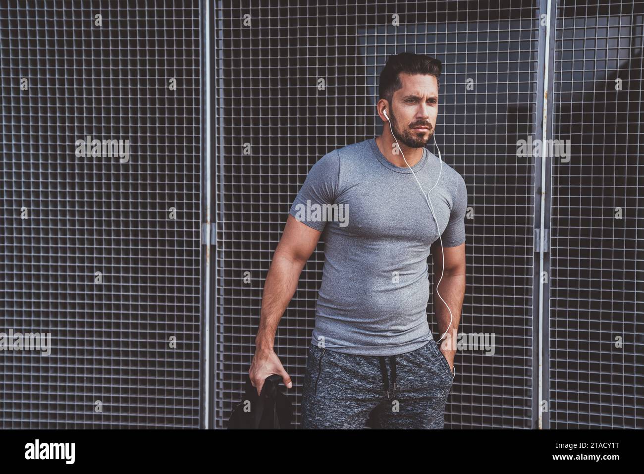 Serious caucasian male athlete with slim muscular body standing on