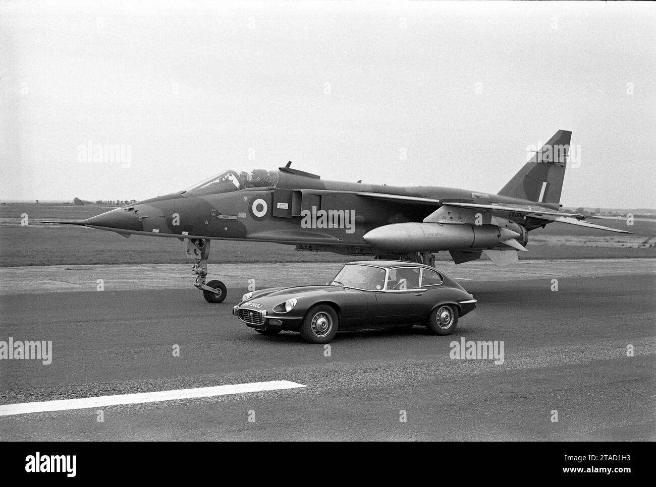 1971 Jaguar E-type Series 3, V12 engine, WHP 205J, parked beside RAF Sepecat prototype Jaguar fighter aircraft on runway Stock Photo