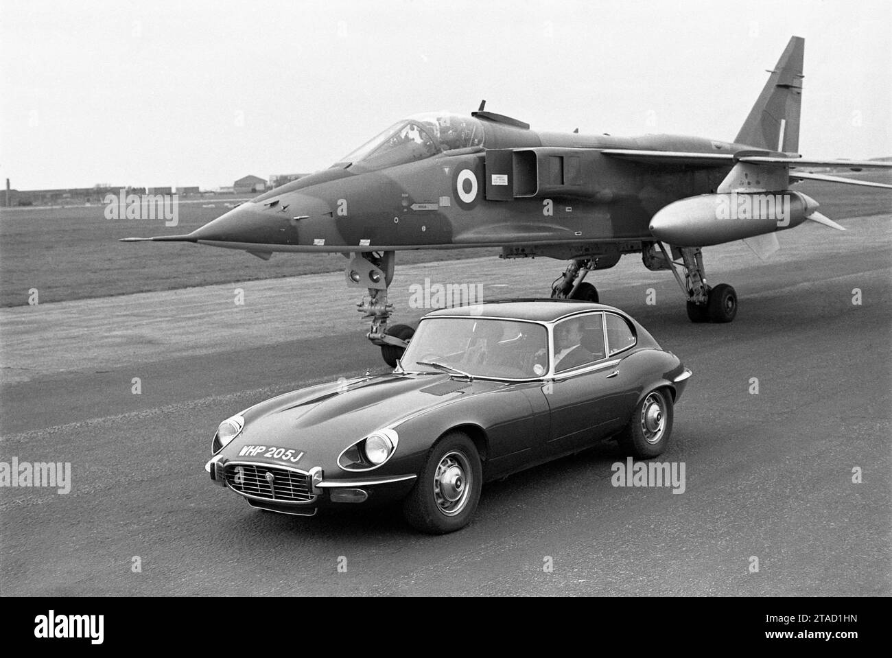 1971 Jaguar E-type Series 3, V12 engine, WHP 205J, parked beside RAF Sepecat prototype Jaguar fighter aircraft on runway Stock Photo