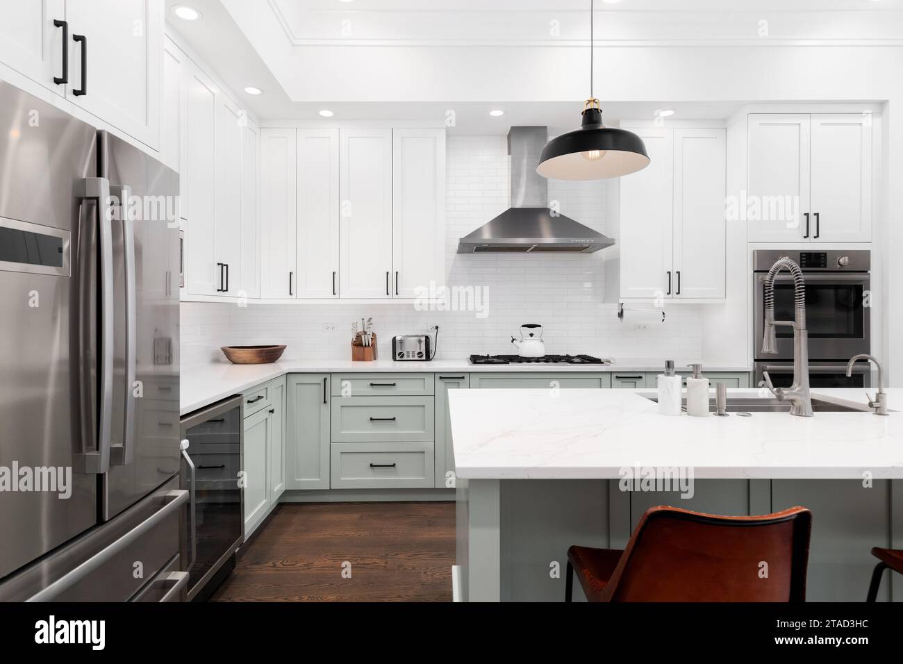 A beautiful kitchen with dark wood cabinets, marble countertops, chairs  sitting at the island, and stainless steel appliances. No brands or names  Stock Photo - Alamy