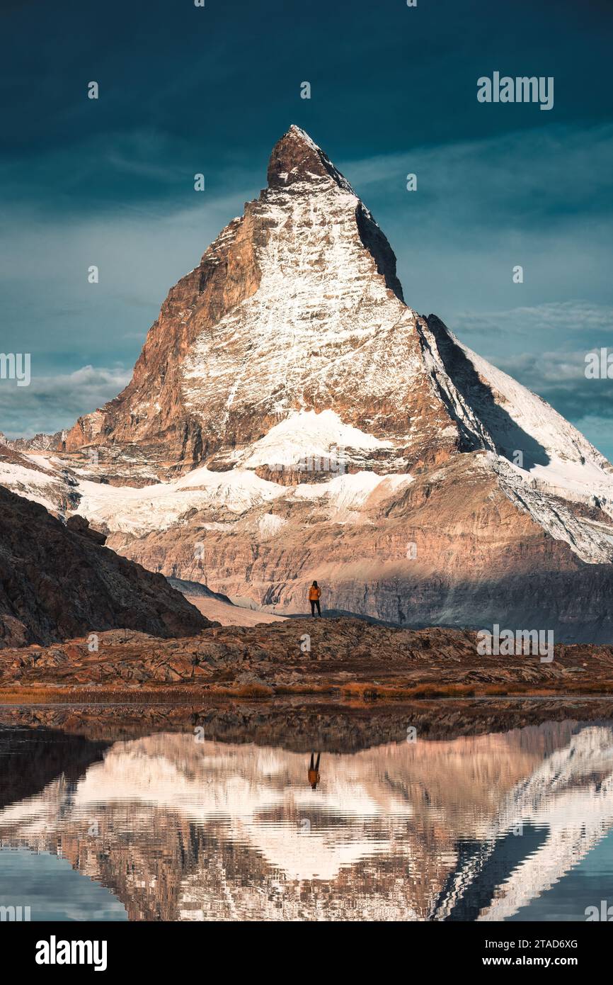 Majestic landscape of Matterhorn iconic mountain with tourist standing reflecs in Riffelsee lake at canton of Valais, Switzerland Stock Photo