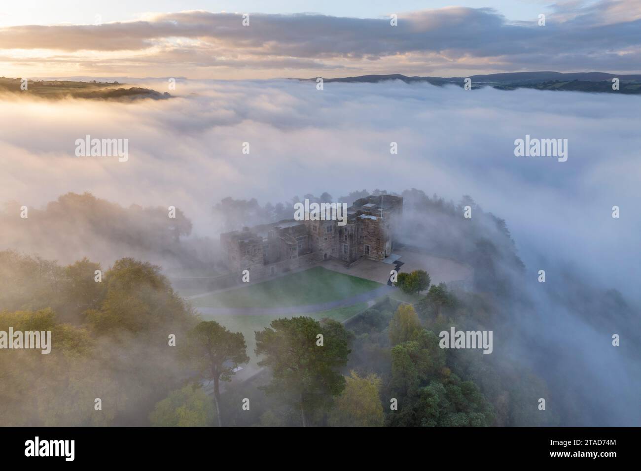 Aerial view of Castle Drogo emerging from a sea of morning mist, Dartmoor National Park, Devon, England.  Autumn (October) 2023. Stock Photo