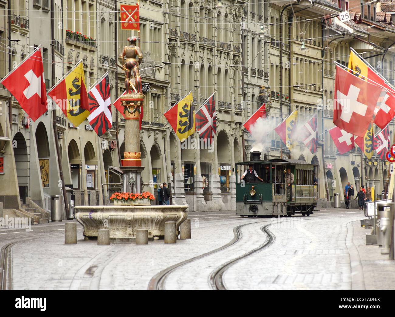 Bern, Switzerland - June 04, 2017: Bern Steam Tram in old city center of Bern and Swiss flags on the facade building. Stock Photo